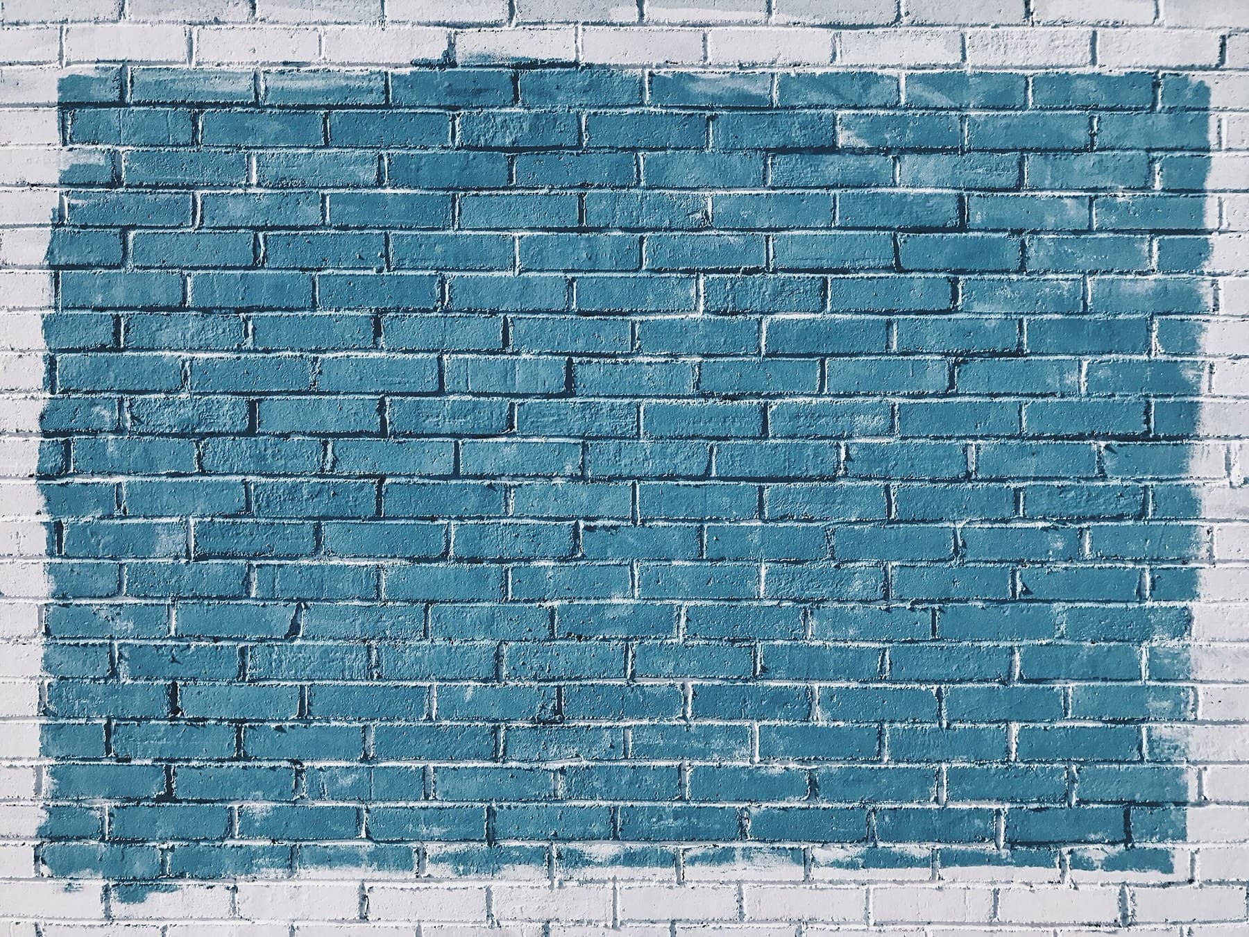 A brick wall with a painted rectangle, ready for a mural